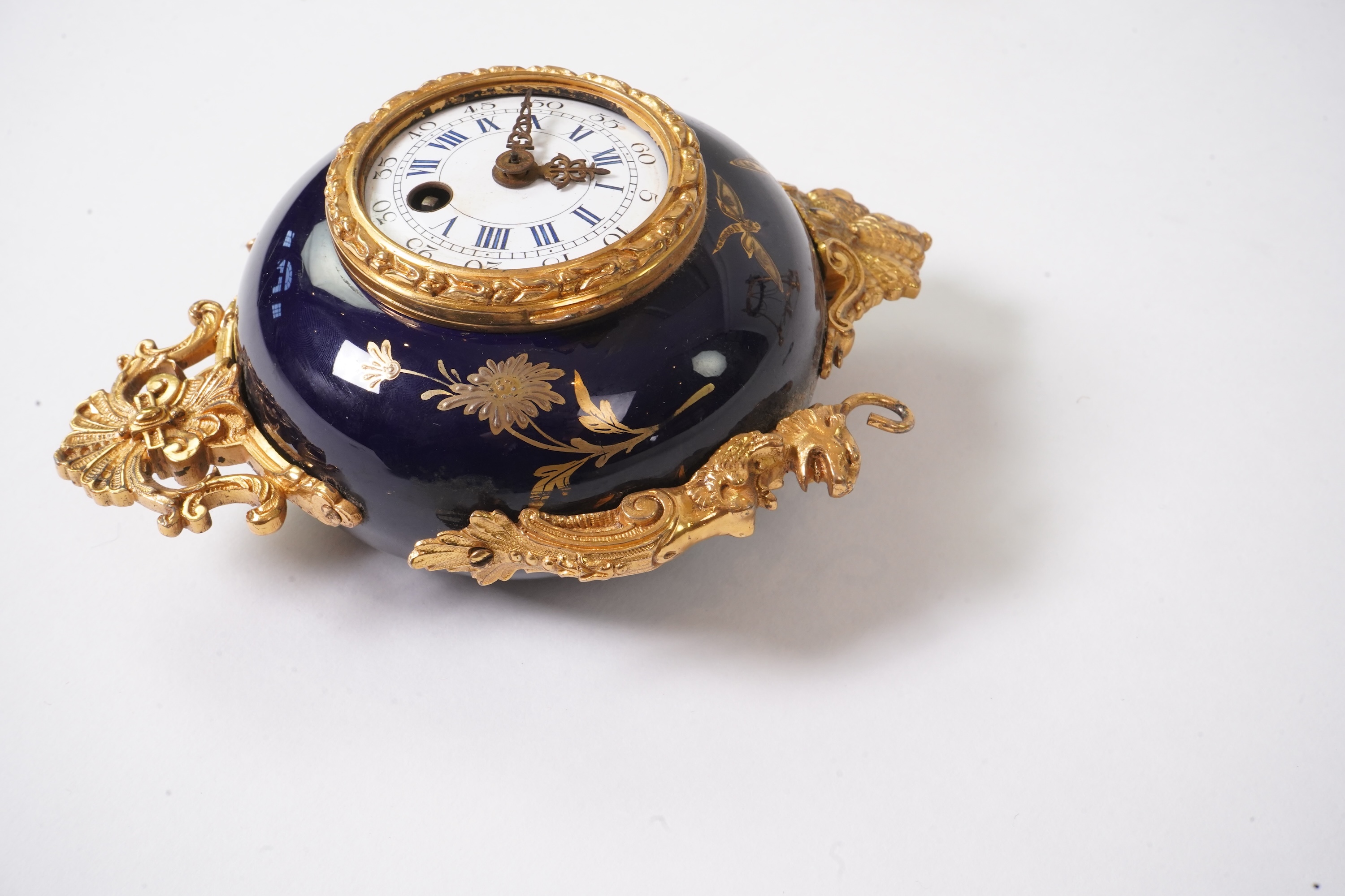 An unusual enamel and gilt brass timepiece, pendant from gilt brass frame, stand 26cm high. Condition - dismantled